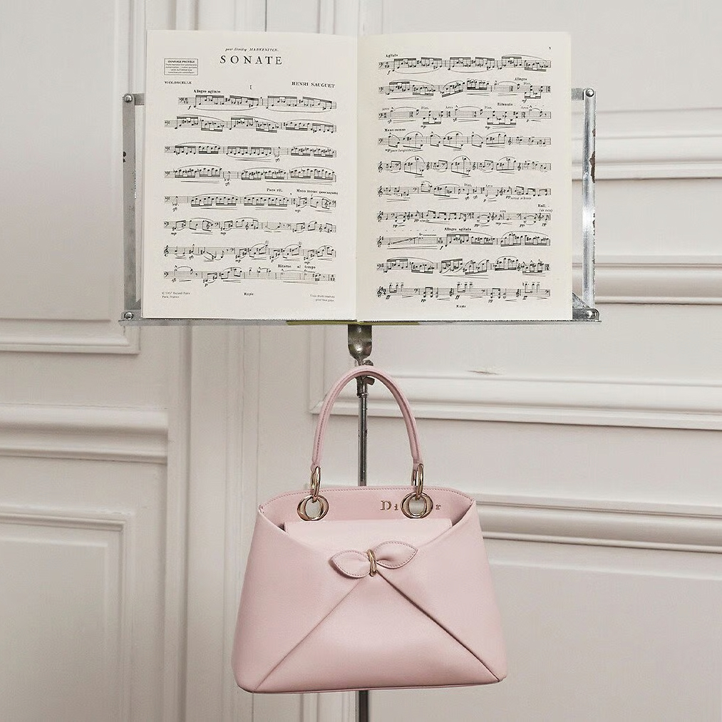 Njena skulpturalna forma direktno je inspirisana couture haljinom La Cigale, koju je Christian Dior kreirao 1952. godine