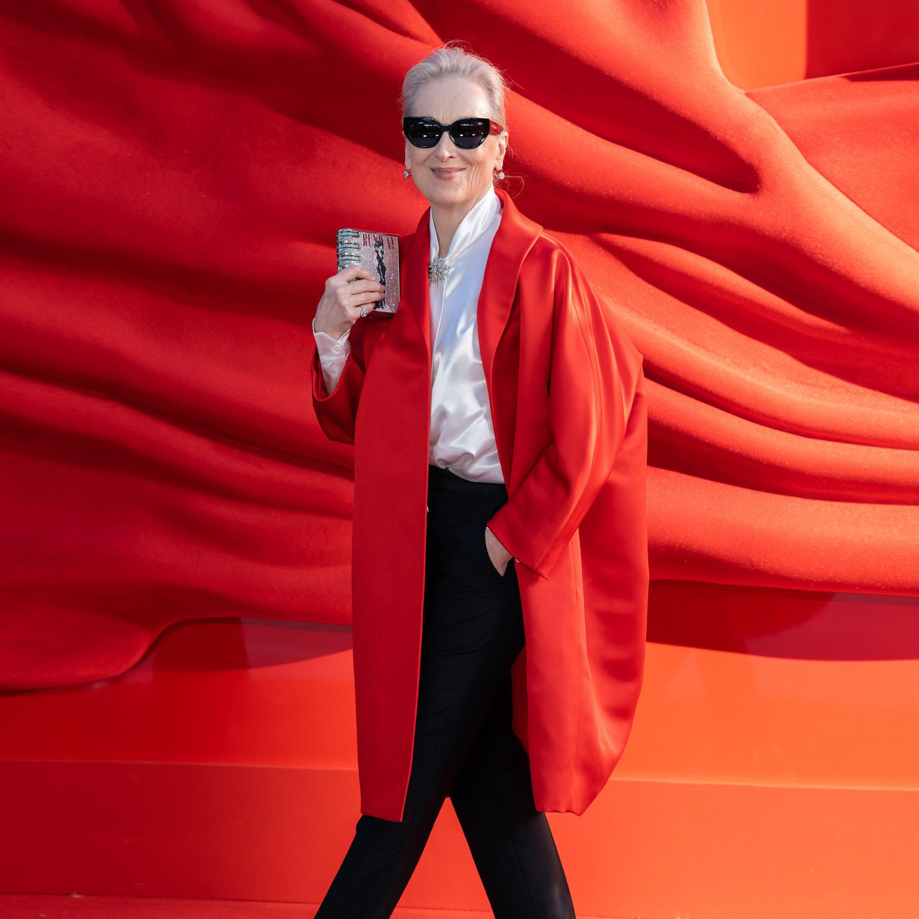 Đavo napokon nosi Pradu! 🔥 Meryl Streep se na londonskoj premijeri filma The Devil Wears Prada 2 pojavila u besprekorno stilizovanom Prada izdanju koje odaje punu počast Mirandi Priestly. Od satenskog Prada kaputa do crvenih štikli i precizno odabranog nakita, svaki detalj bio je promišljen omaž kultnom liku. Najveći modni trenutak večeri? Svetlucava clutch torbica inspirisana „The Book“ — legendarnom maketom Runway magazina iz originalnog filma, koja je ovde dobila luksuznu, minijaturnu reinterpretaciju. Kada se moda, film i ikonografija spoje ovako precizno — rezultat je čista Miranda energija.