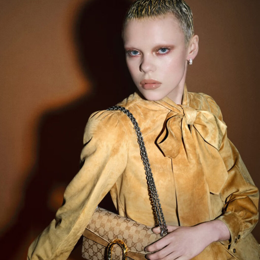 Kreativni direktor modne kuće, Demna Gvasalia, fotografisao je svoje prijatelje i saradnike za najnoviju kampanju pod nazivom Generation Gucci, kojom brend najavljuje novo poglavlje. Pod njegovim vođstvom, Gucci dobija prepoznatljiv zaokret ka sirovijoj i provokativnijoj estetici. Kolekcija „La Famiglia” premijerno je prikazana kao kratki film u septembru 2025. godine, dok je njegova prva revija za Gucci održana u februaru 2026. godine. U oba slučaja, Demna je reinterpretirao istoriju brenda, uz jasno poštovanje njegovog nasleđa — a kolekcija jesen/zima 2026. čak se nadovezuje na čuvenu Tom Ford eru. Nova kampanja Generation Gucci pokazuje još jedan pravac u razvoju brenda.